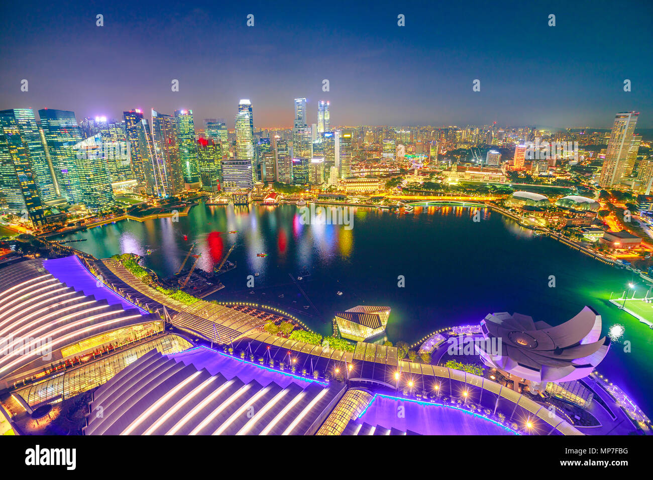 Luftaufnahme von Singapur Marina Bay mit Financial District Wolkenkratzer bei Nacht beleuchtet am Hafen wider. Oben auf dem Dach Skyline von Singapur. Nacht städtische Szene. Stockfoto