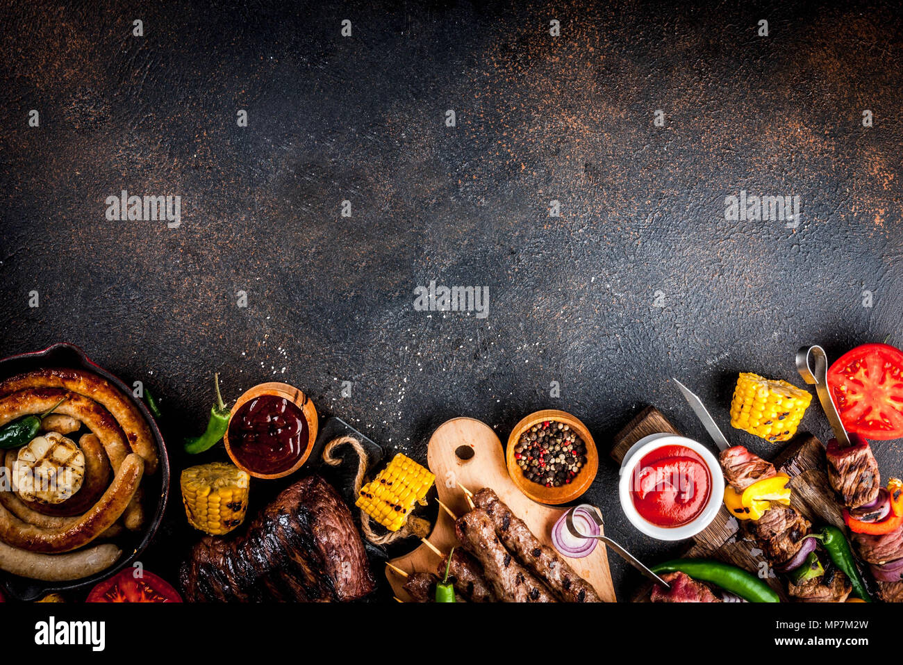 Sortiment verschiedene Barbecue Grill Fleisch, bbq Party fest - Shish Kebab, Würstchen, gegrillten Fleisch Filet, frisches Gemüse, Soßen, Gewürze, dunklen Rusty Stockfoto