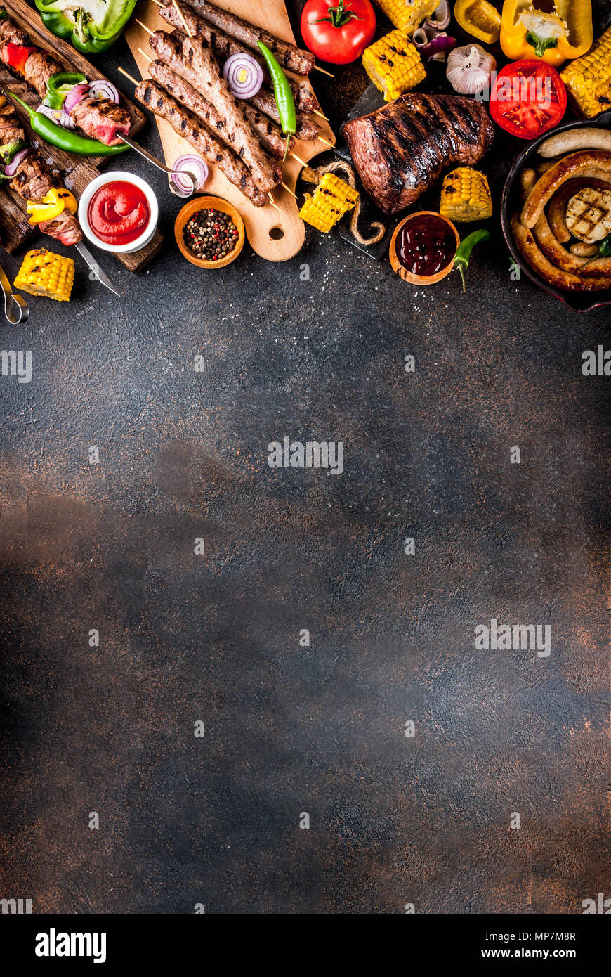 Sortiment verschiedene Barbecue Grill Fleisch, bbq Party fest - Shish Kebab, Würstchen, gegrillten Fleisch Filet, frisches Gemüse, Soßen, Gewürze, dunklen Rusty Stockfoto