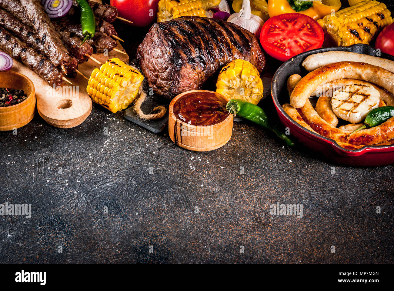 Sortiment verschiedene Barbecue Grill Fleisch, bbq Party fest - Shish Kebab, Würstchen, gegrillten Fleisch Filet, frisches Gemüse, Soßen, Gewürze, dunklen Rusty Stockfoto