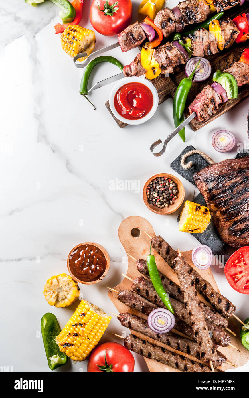Sortiment verschiedene Barbecue Grill Fleisch, bbq Party fest - Shish Kebab, Würstchen, gegrillten Fleisch Filet, frisches Gemüse, Soßen, Gewürze, weiße Marb Stockfoto