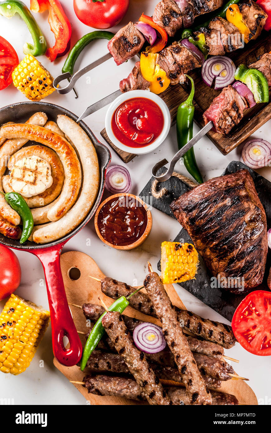 Sortiment verschiedene Barbecue Grill Fleisch, bbq Party fest - Shish Kebab, Würstchen, gegrillten Fleisch Filet, frisches Gemüse, Soßen, Gewürze, weiße Marb Stockfoto