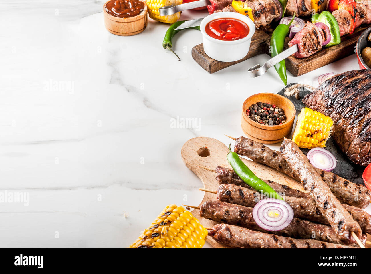 Sortiment verschiedene Barbecue Grill Fleisch, bbq Party fest - Shish Kebab, Würstchen, gegrillten Fleisch Filet, frisches Gemüse, Soßen, Gewürze, weiße Marb Stockfoto