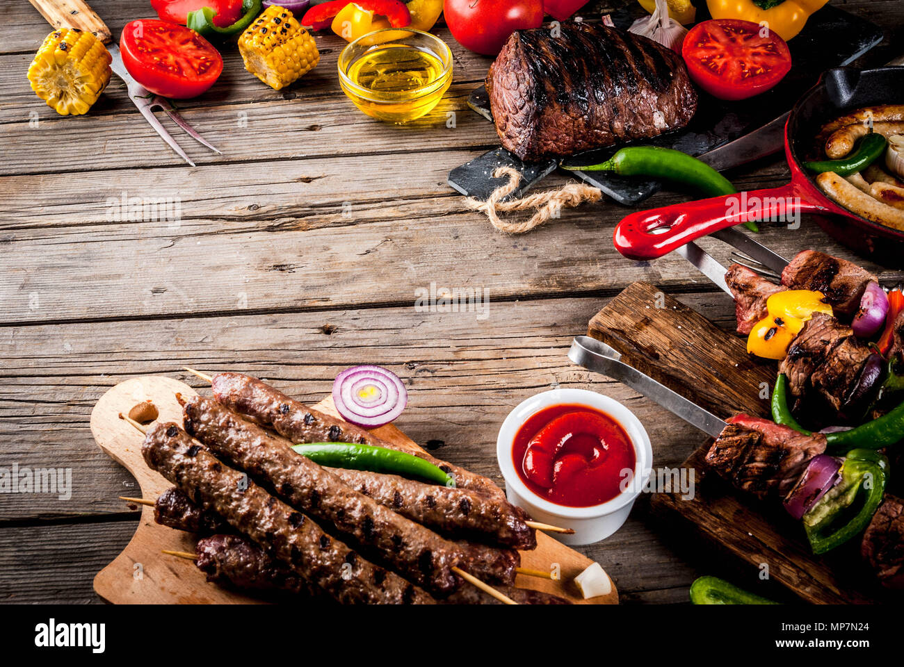 Sortiment verschiedene Barbecue Grill Fleisch, bbq Party fest - Shish Kebab, Würstchen, gegrillten Fleisch Filet, frisches Gemüse, Soßen, Gewürze, auf alten Woo Stockfoto