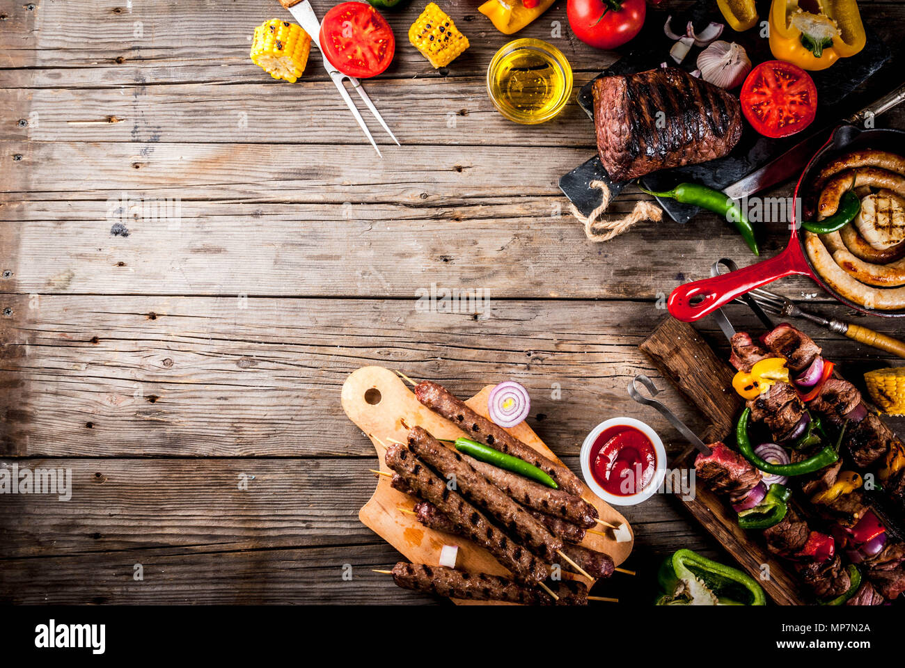 Sortiment verschiedene Barbecue Grill Fleisch, bbq Party fest - Shish Kebab, Würstchen, gegrillten Fleisch Filet, frisches Gemüse, Soßen, Gewürze, auf alten Woo Stockfoto