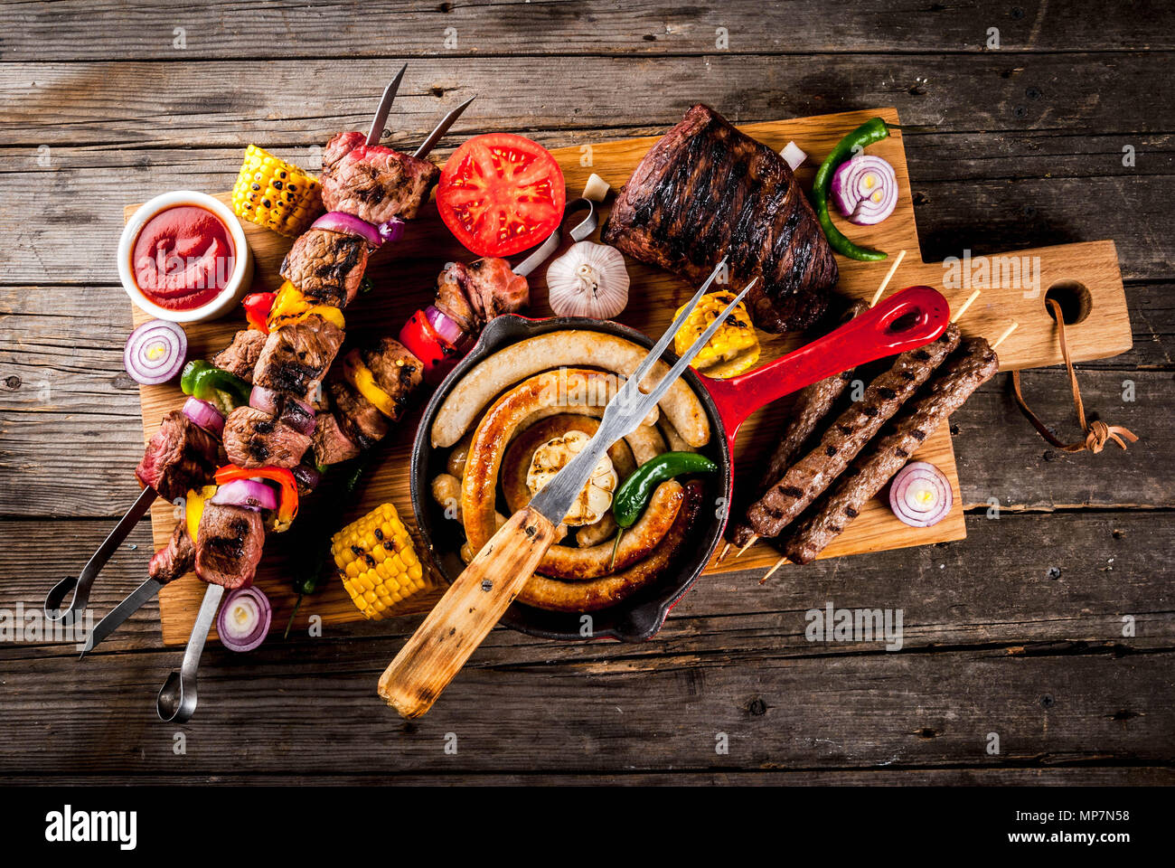Sortiment verschiedene Barbecue Grill Fleisch, bbq Party fest - Shish Kebab, Würstchen, gegrillten Fleisch Filet, frisches Gemüse, Soßen, Gewürze, auf alten Woo Stockfoto
