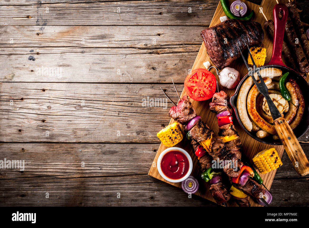 Sortiment verschiedene Barbecue Grill Fleisch, bbq Party fest - Shish Kebab, Würstchen, gegrillten Fleisch Filet, frisches Gemüse, Soßen, Gewürze, auf alten Woo Stockfoto