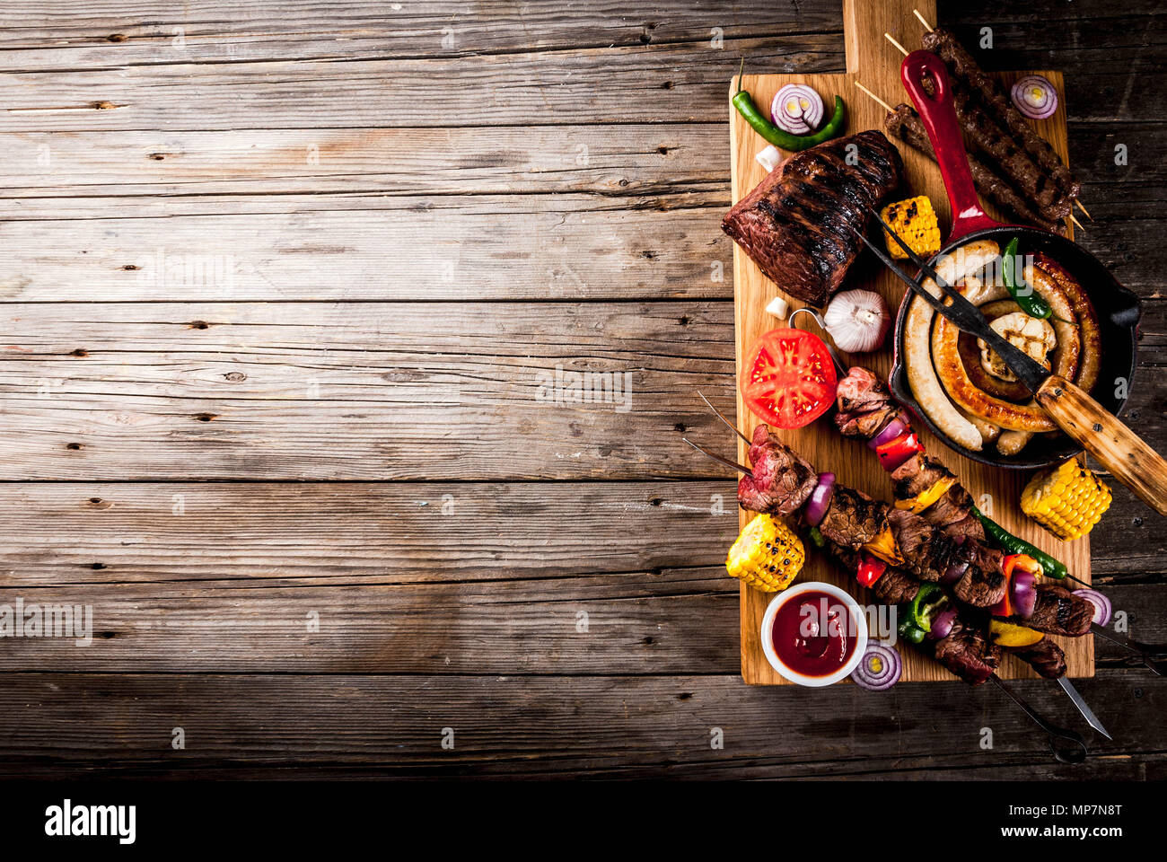 Sortiment verschiedene Barbecue Grill Fleisch, bbq Party fest - Shish Kebab, Würstchen, gegrillten Fleisch Filet, frisches Gemüse, Soßen, Gewürze, auf alten Woo Stockfoto