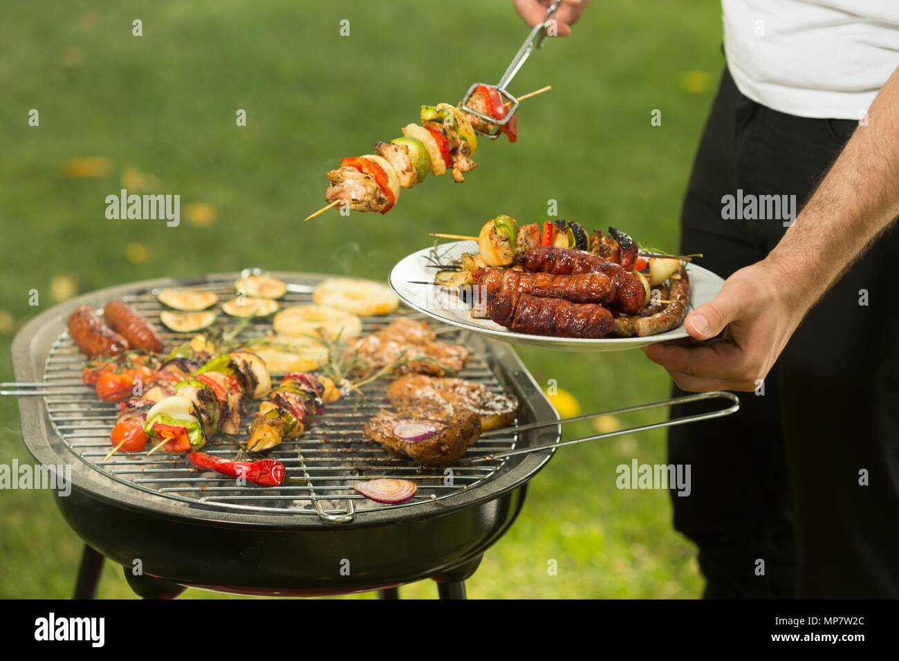 Geschossen von einem Mann einen Grill in Stockfoto