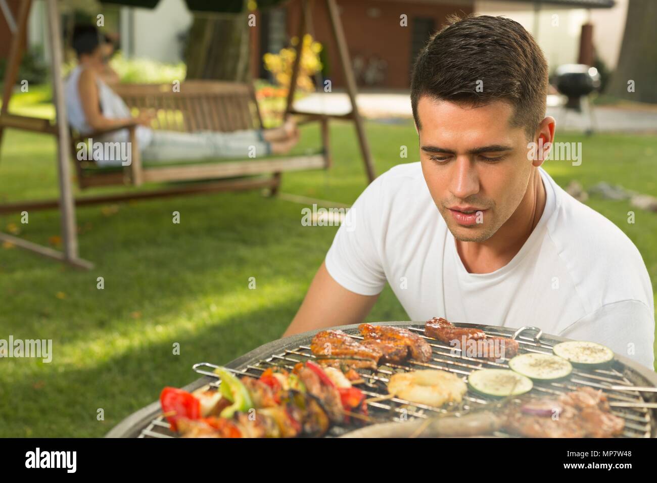 Junge schöne Grill Chef gerade die Grill Stockfoto