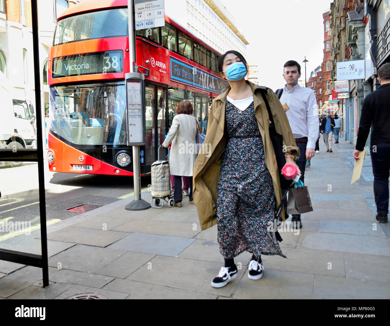 Japanische Frau trägt eine Gesichtsmaske in Central London, England, UK. Stockfoto