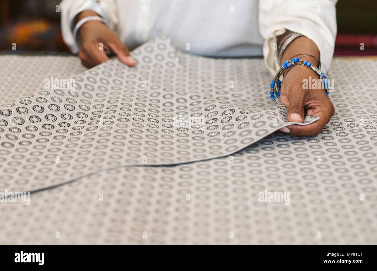 Nahaufnahme einer Frau Textilien Inspektion in Ihrem Gewebe shop Stockfoto