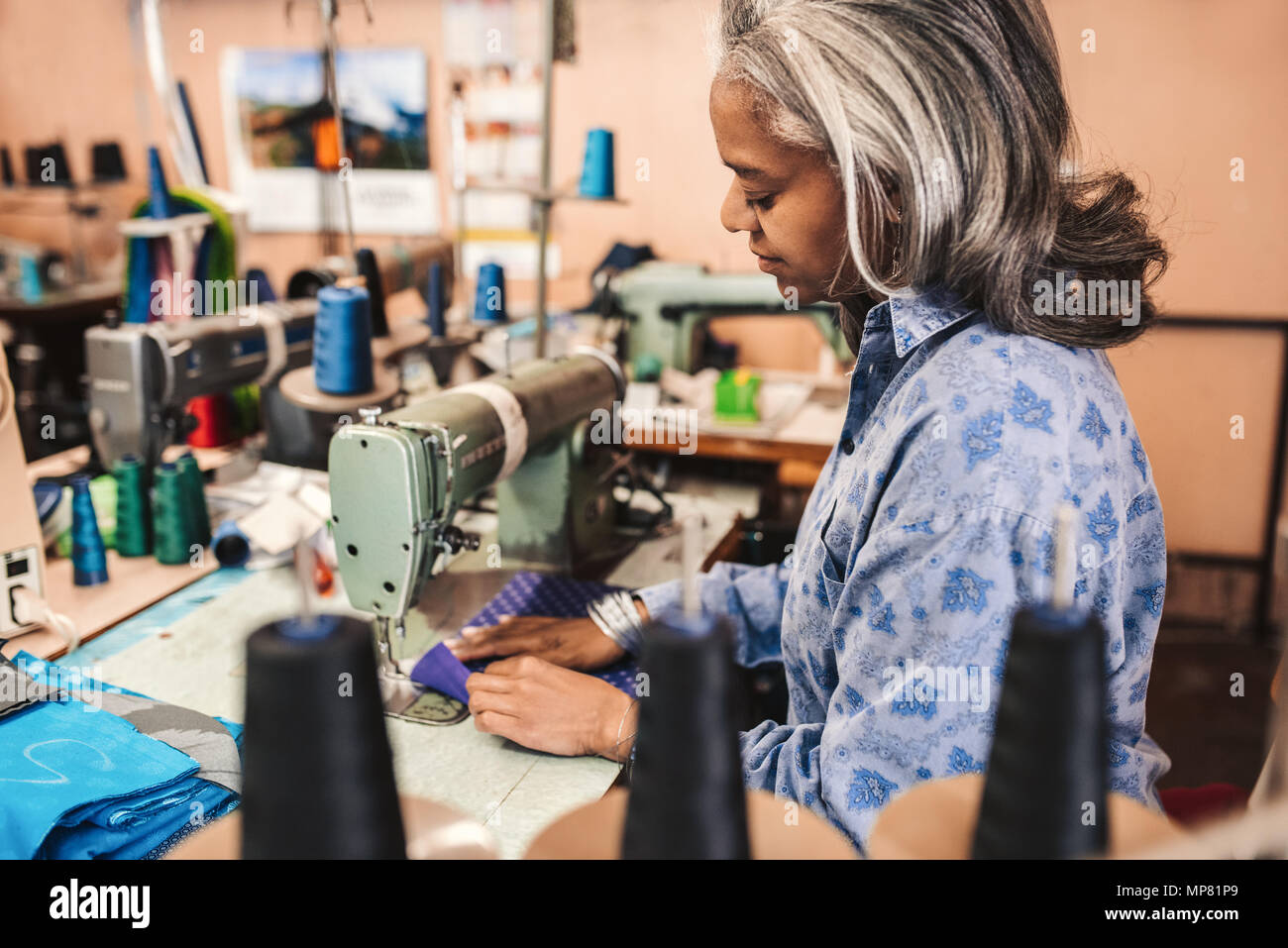 Reife Frau nähen Tuch in ihre Kleidung workshop Stockfoto