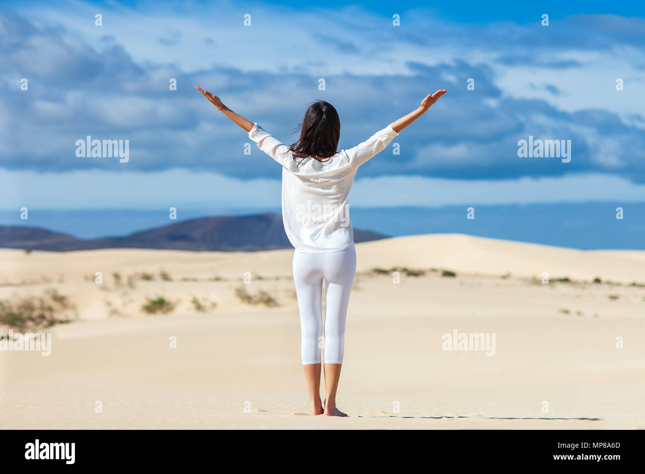 Glückliche junge Frau, die Natur genießen, mit offenen Händen auf Wüste, Kanarische Inseln, Spanien. Freiheit Konzept Stockfoto