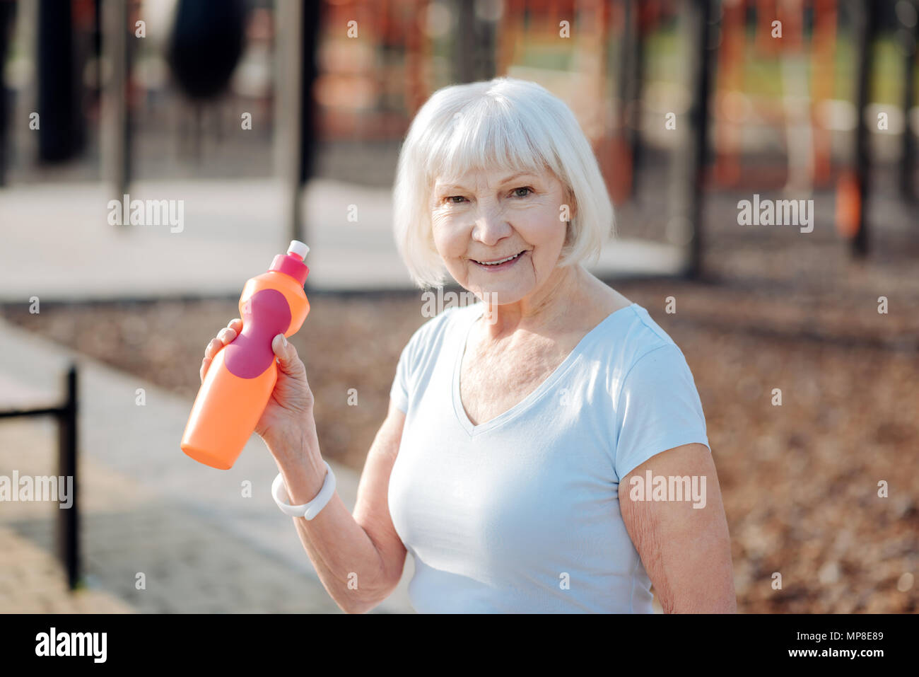 Fröhliche Frau trinken einige Saft Stockfoto