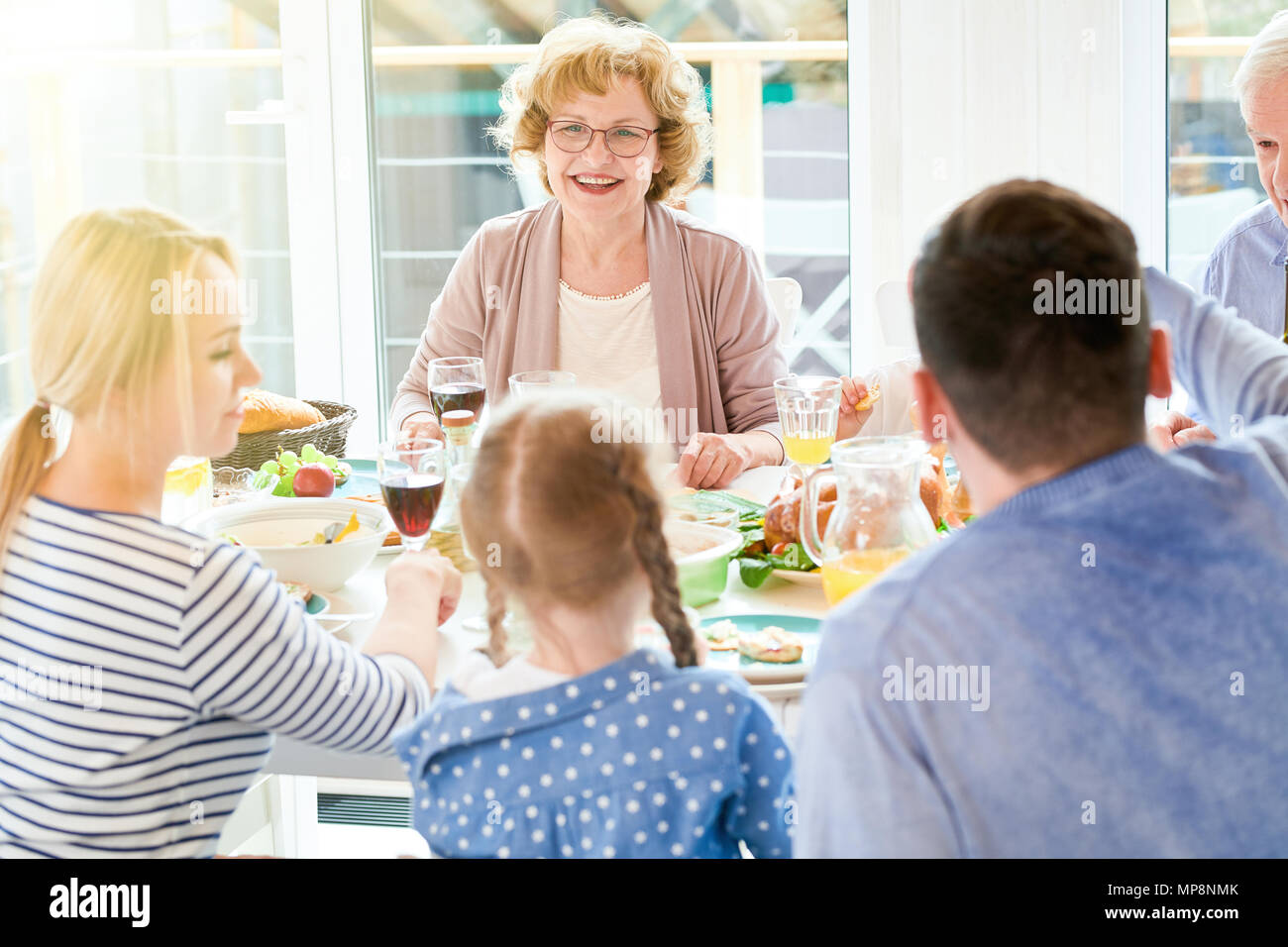 Großmutter genießen Familie Abendessen im Sonnenlicht Stockfoto