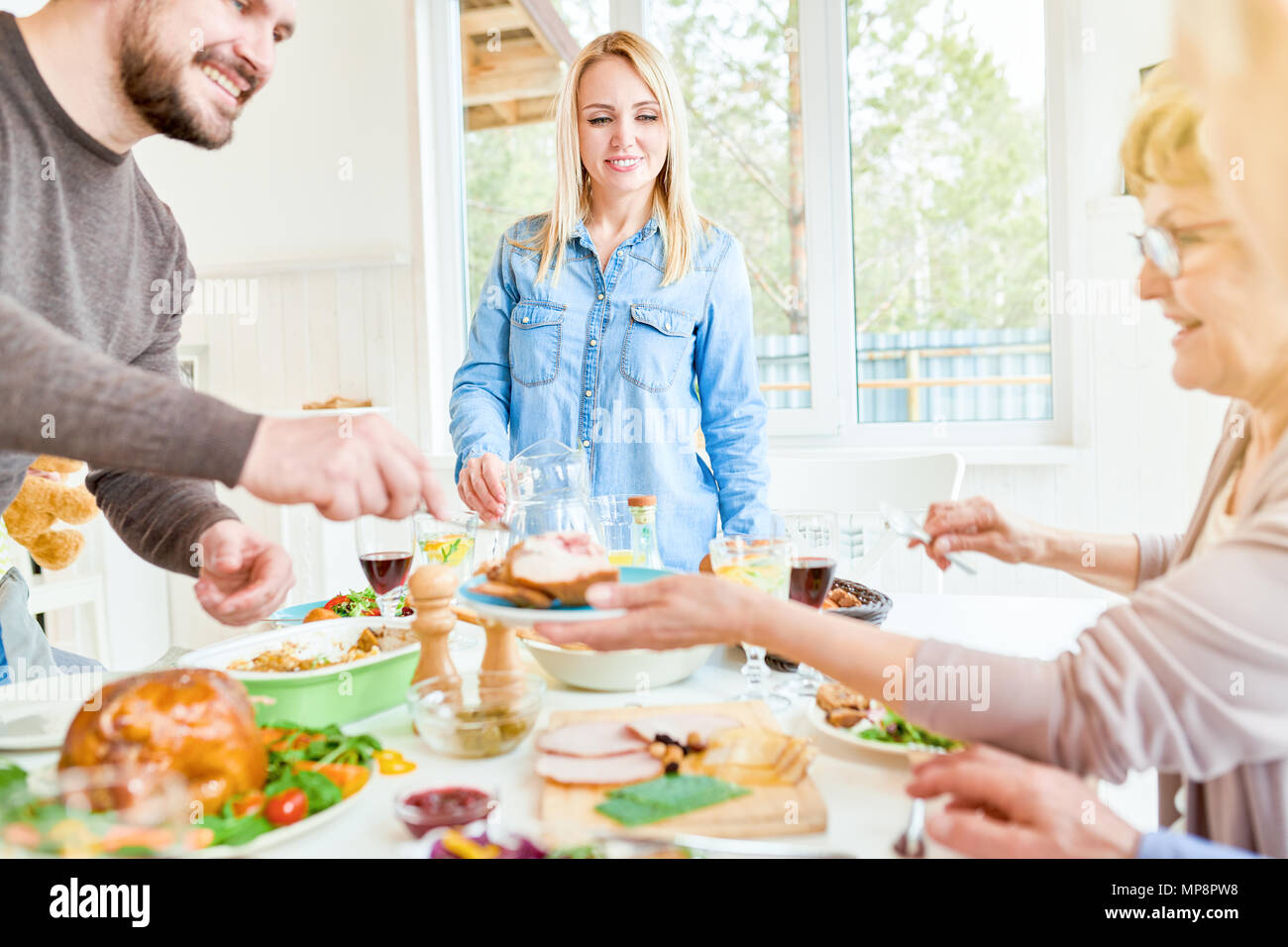 Junge Frau Hosting Abendessen mit der Familie Stockfoto