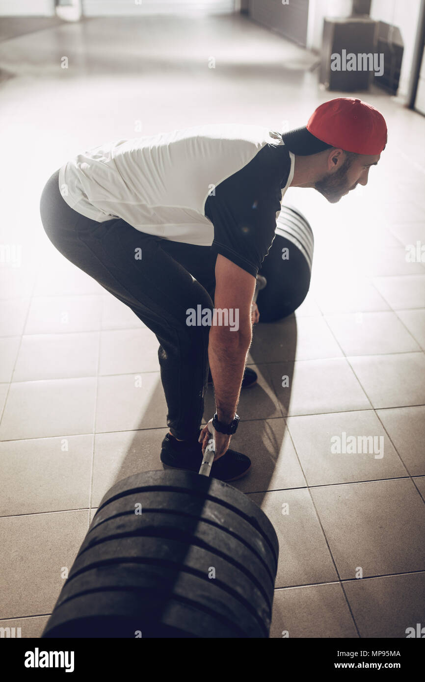 Junge muskulöse Mann bereit, Übung in der garage Gym zu deadlift. Stockfoto