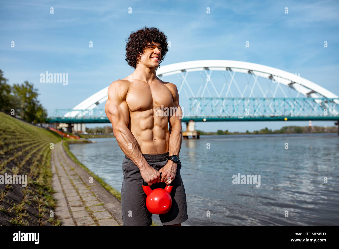 Bodybuilder mit Six Pack, perfekte ABS, Schultern, Bizeps, Trizeps und Brust  tut gut geeignet sind Körper Training mit kettlebell, in der Nähe des  Flusses Stockfotografie - Alamy