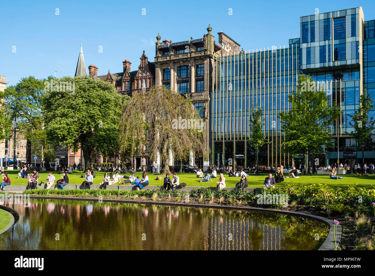 Leute sitzen auf Gras in St Andrews Square in warmen, sonnigen Wetter in Edinburgh, Schottland, Vereinigtes Königreich, Großbritannien Stockfoto