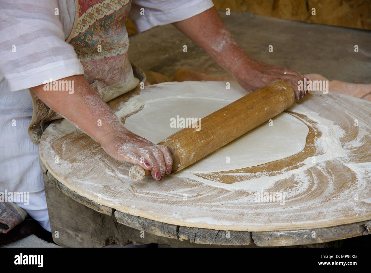 Eine Frau rollt Teig lavash (ein traditionelles Fladenbrot), das dann in einem Tandoor Ofen, Garni wird gebacken, Armenien zu machen Stockfoto