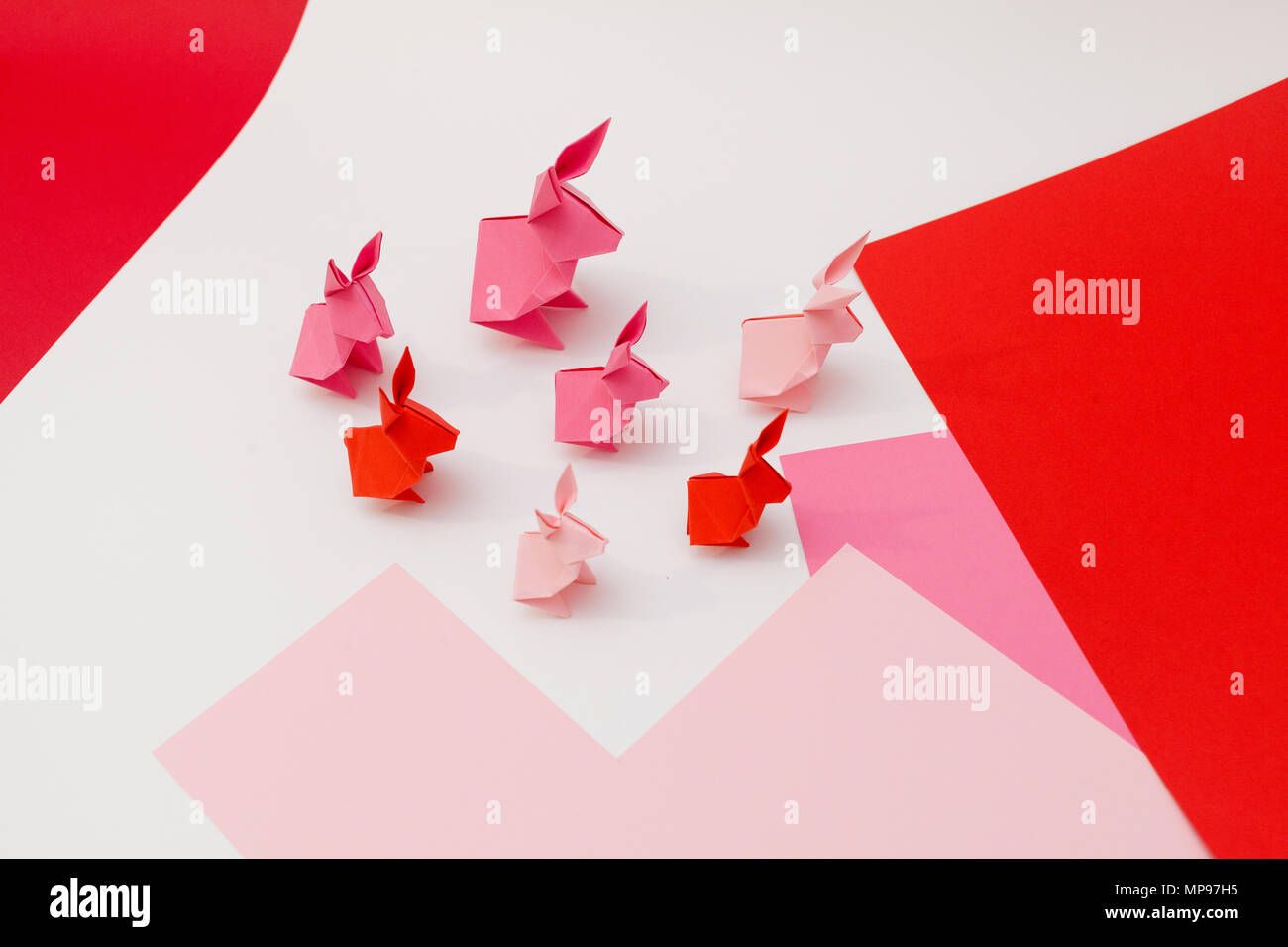 Sieben rosa origami Kaninchen in Pink und White Paper Stockfoto
