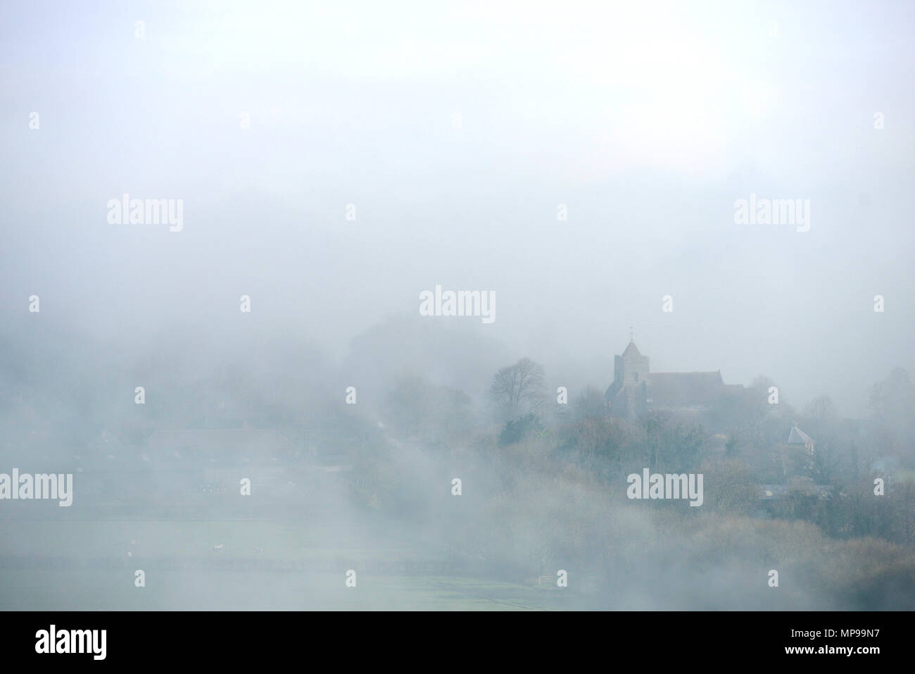 Dorfkirche aus tick Nebel. Stockfoto