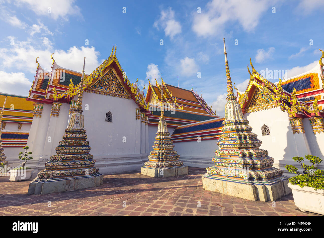 Gebäude und vielen verzierten Chedis des Wat Pho Tempel in Bangkok, der an einem sonnigen Tag. Wahrzeichen von Thailand Stockfoto