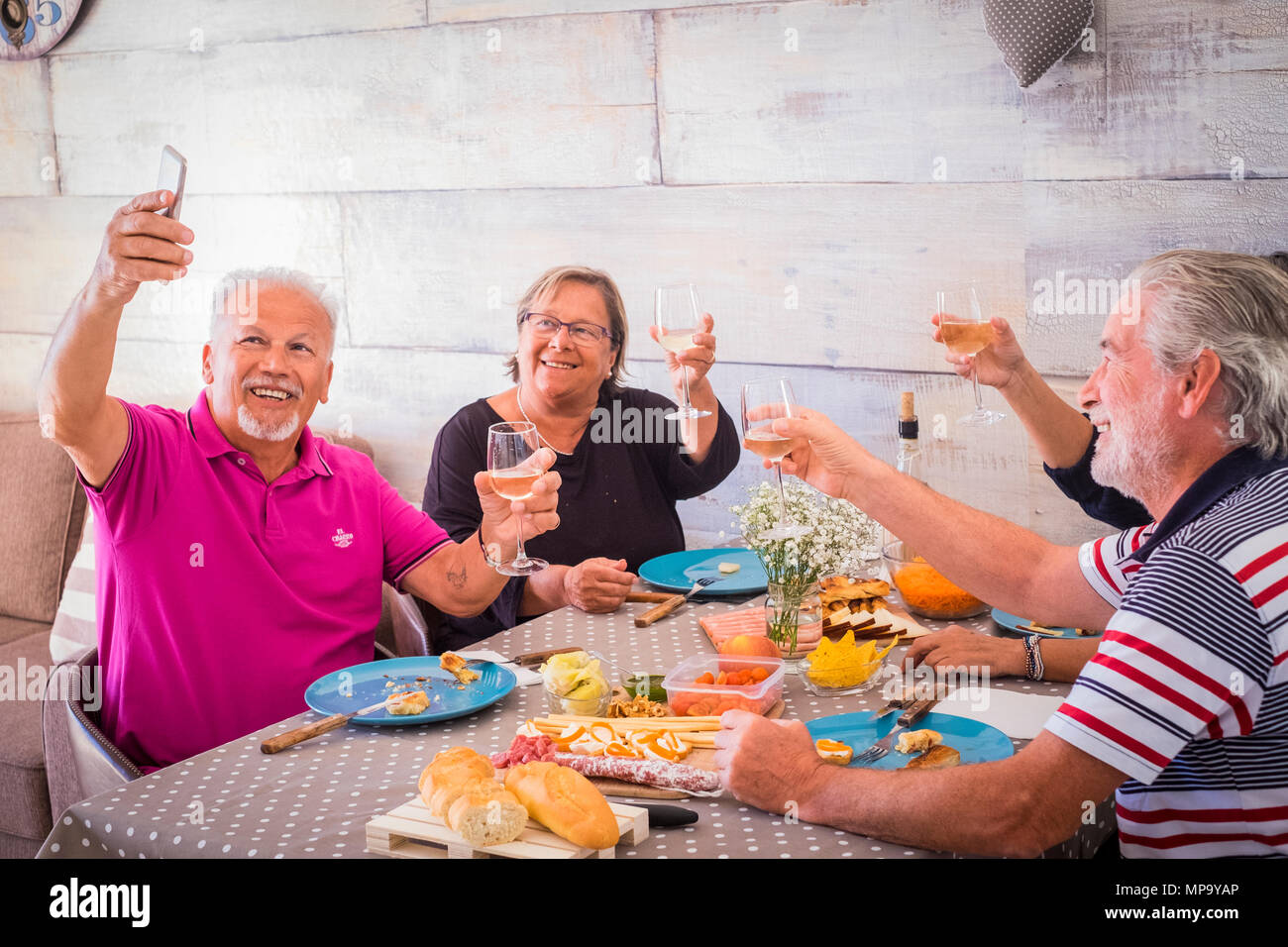 Ältere Ehepaare nehmen selfie zu Hause toasten rot Wein und essen zu Mittag essen - alte freunde Spaß mit neuen Trends Technologie Stockfoto
