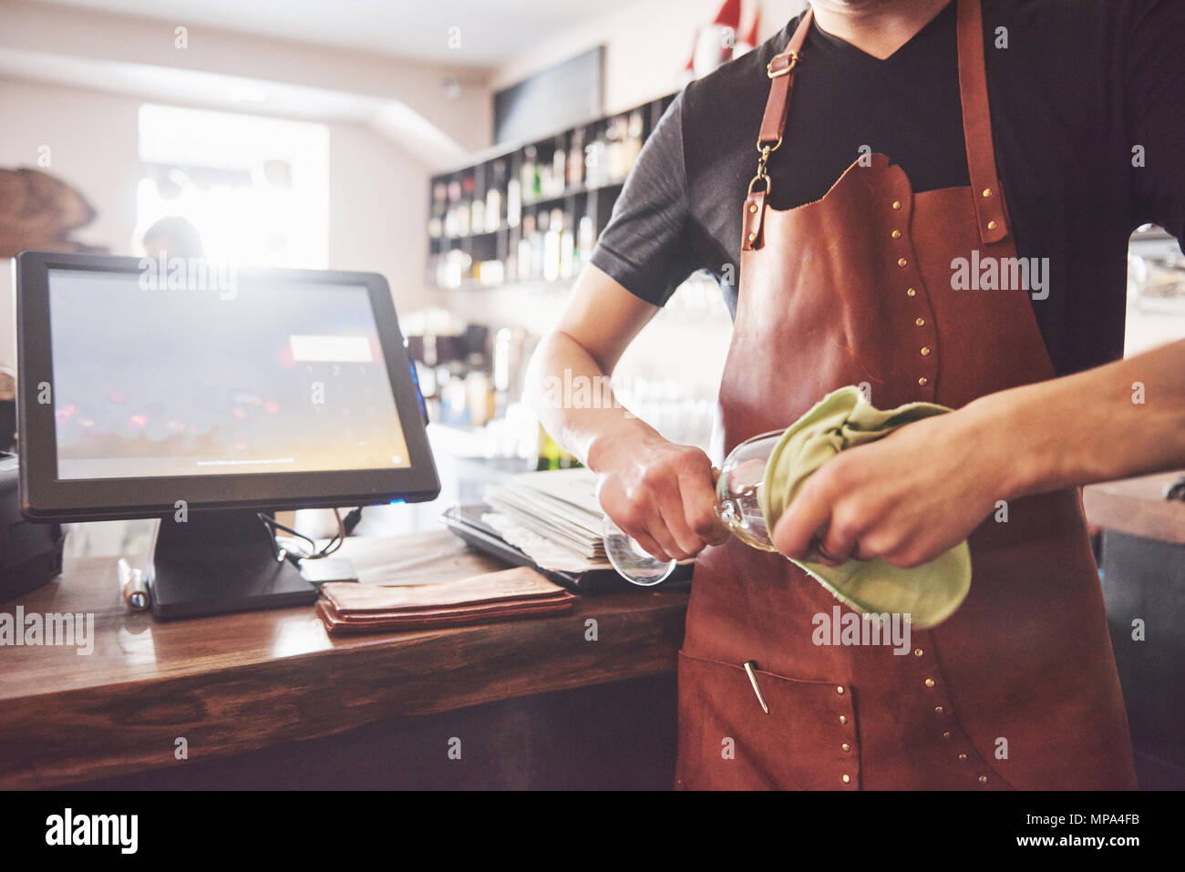 Der Barkeeper in der Bar Inneneinrichtung Die alkohol Cocktail. Professionelle Bartender gießt Getränk mit einem Sieb Stockfoto
