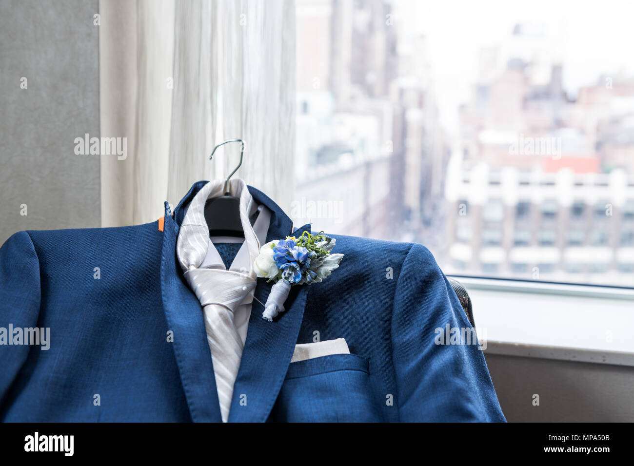 Herren Anzug und Krawatte Bräutigam closeup mit Blume, Anstecker, pin Hochzeit Vorbereitung, pocket Taschentuch, Fenster mit Blick auf die Stadt New York City NYC Ma Stockfoto
