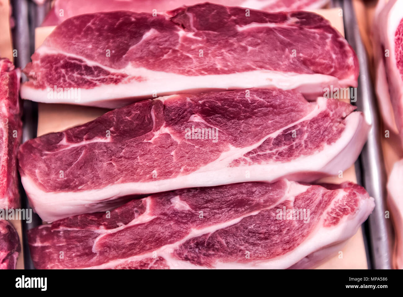 Red raw fettes Fleisch Schwein oder Rind Kotelettstränge ohne Knochen mit Fett in Store Display, Fächer für Verkauf closeup Stockfoto