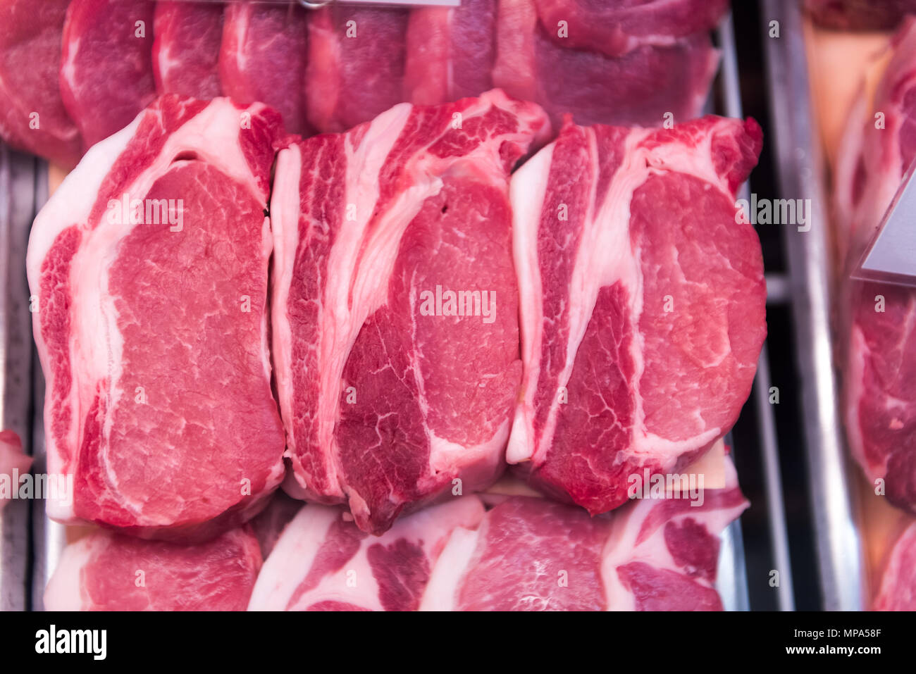 Red rohes Rindfleisch Kotelettstränge ohne Knochen oder fettes Fleisch Schweinefleisch mit Fett in Store Display, Fächer für Verkauf closeup Stockfoto