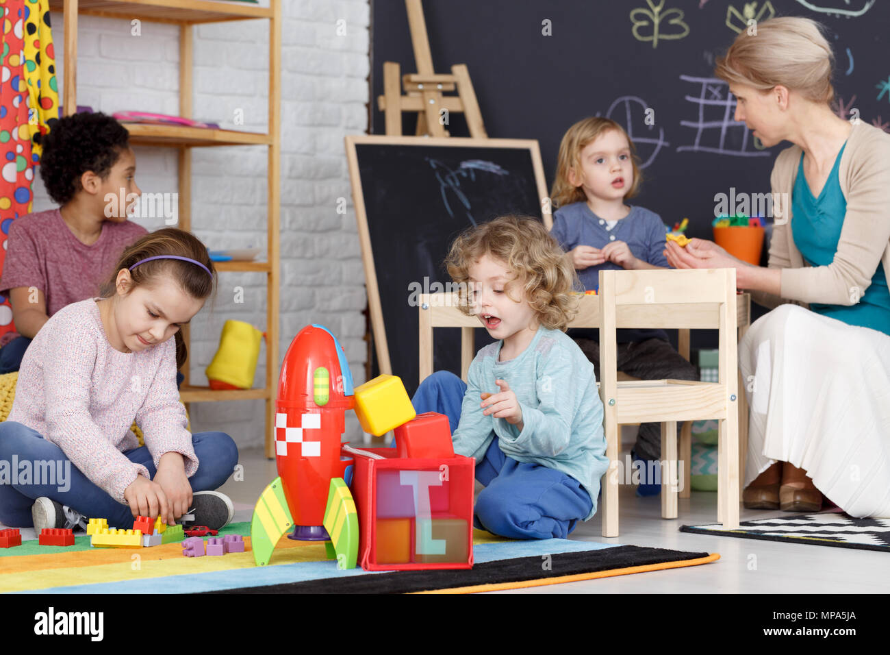 Gruppe der Vorschule Kinder mit Spielzeug spielen auf einem Teppich