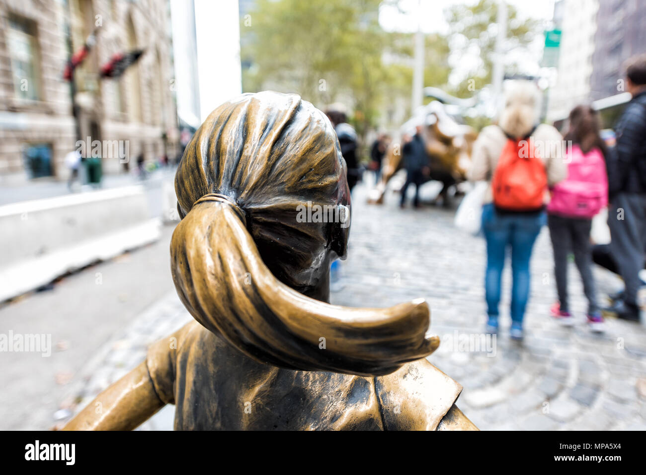 New York City, USA - 30. Oktober 2017: Wall Street Börse Der Furchtlose Mädchen Statue vor wütenden Stier Metall in NYC Manhattan geringere finanzielle Stockfoto