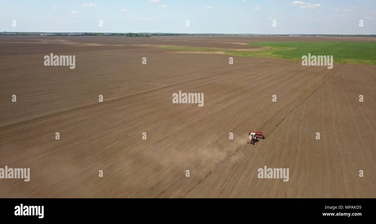 Traktor pflegt das Feld, Feder arbeitet auf Ackerland. Foto von der Drohne Stockfoto