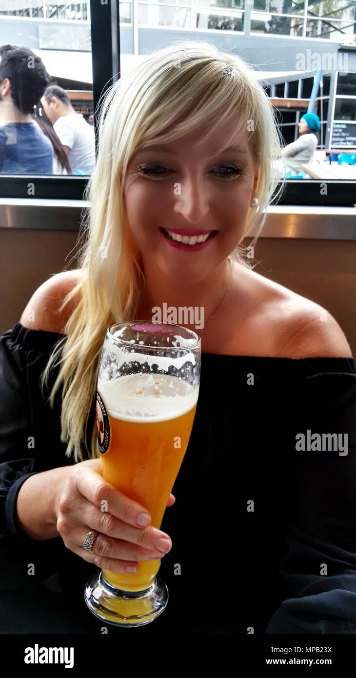 Blonde Frau Bier trinken. Stockfoto