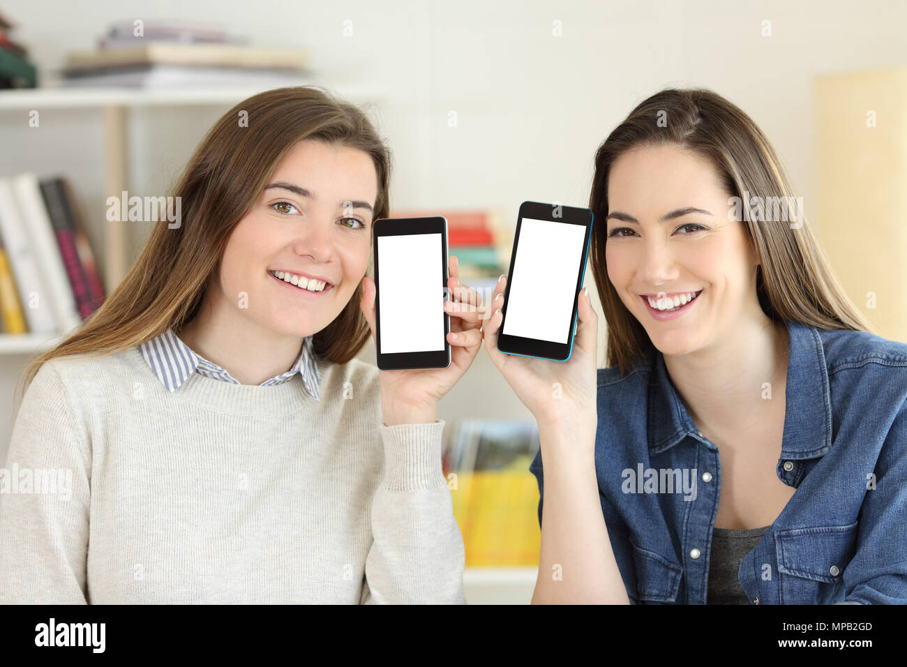 Vorderansicht Portrait von zwei glückliche Schüler zeigen zu Kamera smart phone Bildschirme mockup Stockfoto