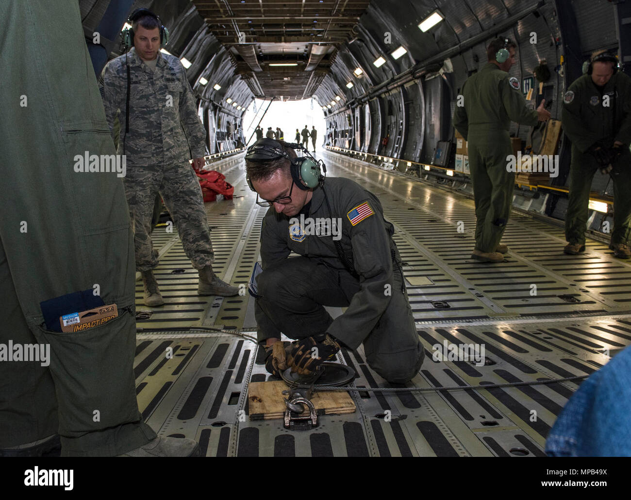 Us Air Force Aircrew Mitglieder für die 22 Airlift Squadron Arbeit zu laden und sichern eine hohe Mobilität Multipurpose Radfahrzeug (Hmmwv) auf eine C5-M Super Galaxy Flugzeuge während der arbeitet mit Flieger Programm, 7. April 2017. Das Programm sieht die Führung der Interaktion mit Fliegern eine detaillierte Ansicht der Mission bei Travis durchgeführt. Stockfoto
