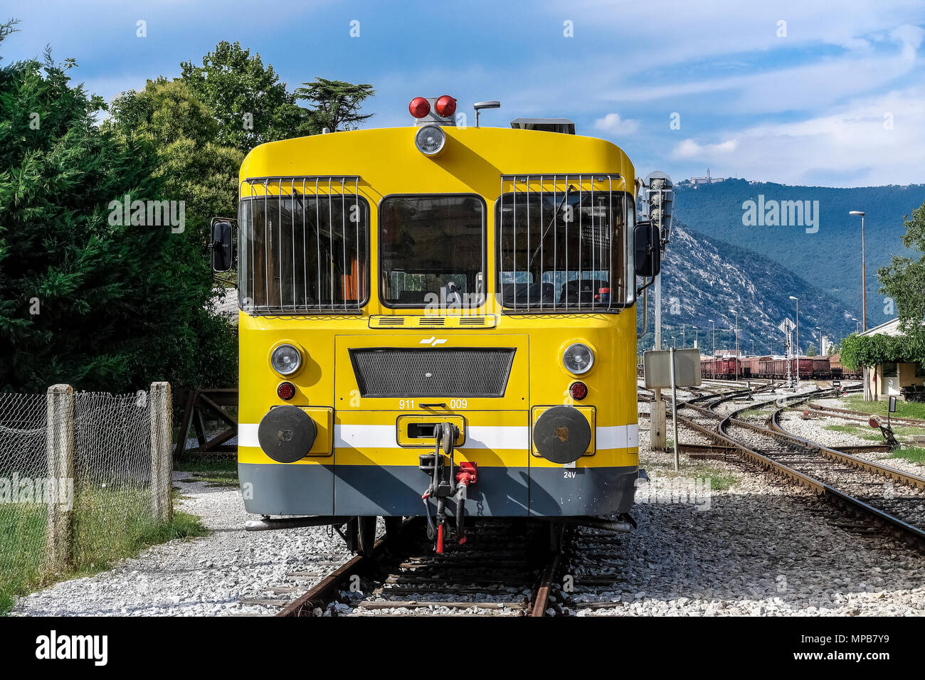 Eisenbahnbaumaschinen, gelbe Bahnleitungs-Wartungsdraisine auf offener Schiene, etwas außerhalb Nova Gorica Bahnhof, Slowenien, EU Stockfoto