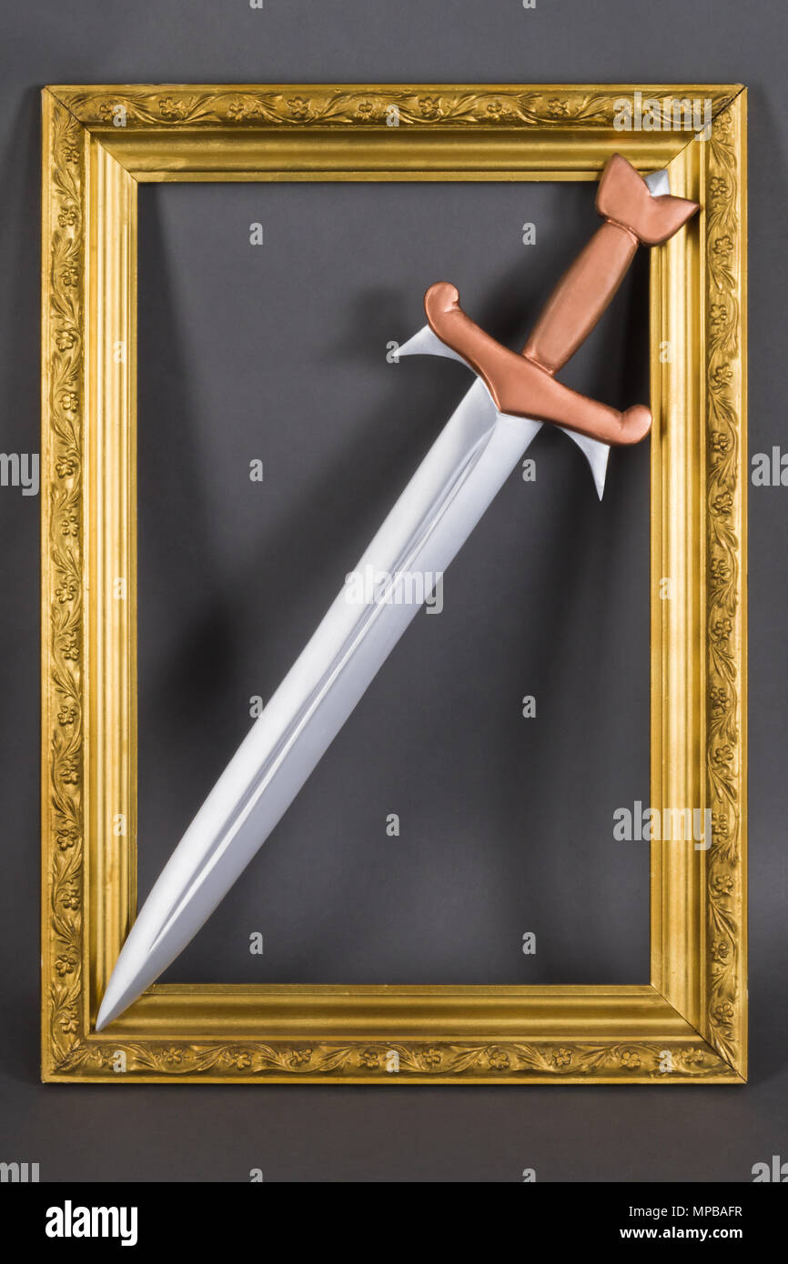 Stahl Schwert mit Bronze Griff in gold baguette Rahmen. Mittelalterliche Symbol der Aristokratie und des Adels Stockfoto