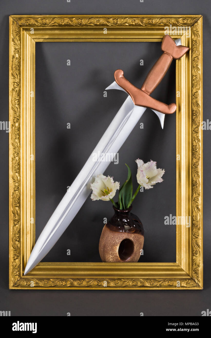 Stahl Schwert mit Bronze Griff und White Tulip Blumen in Gold baguette Rahmen. Mittelalterliche Symbol der Aristokratie und des Adels Stockfoto