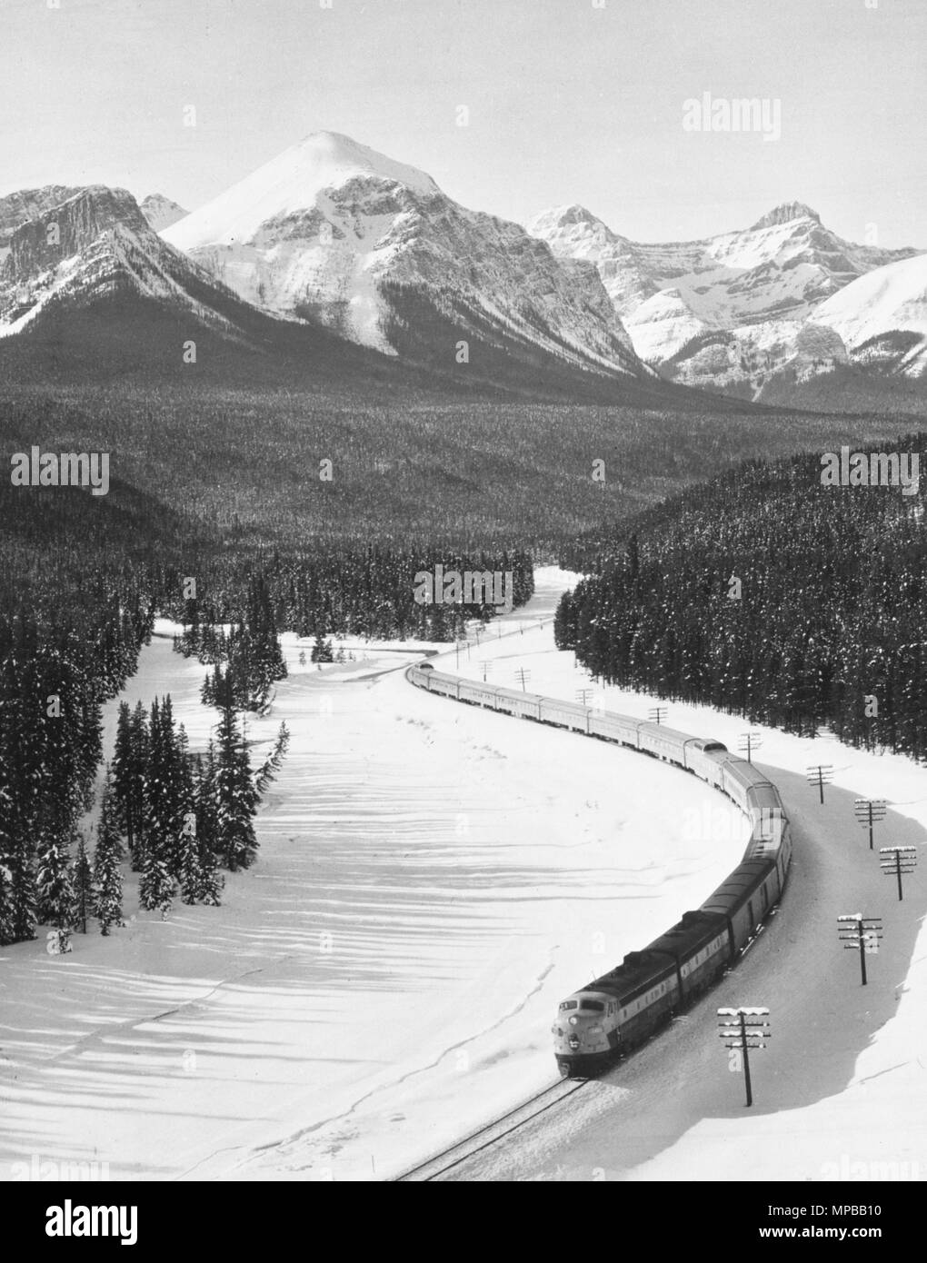 Zwei Diesel Lokomotive Einheiten am Kopfende, die Canadian Pacific Edelstahl Zug - Der Kanadische-threads seinen Weg entlang der Ufer des zugefrorenen Bow River, in der Nähe von Lake Louise in den kanadischen Rockies. Stockfoto
