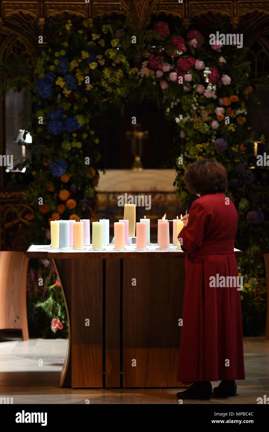 Ein Mitglied des Klerus leuchten Kerzen für die Opfer während der Manchester Arena National Service der Gedenkfeier in der Kathedrale von Manchester zu einem Jahr seit dem Angriff auf Manchester Arena. Stockfoto