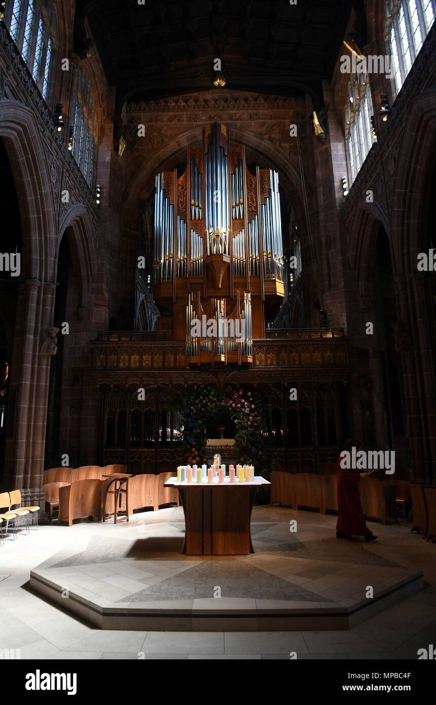 Ein Mitglied des Klerus leuchten Kerzen für die Opfer während der Manchester Arena National Service der Gedenkfeier in der Kathedrale von Manchester zu einem Jahr seit dem Angriff auf Manchester Arena. Stockfoto