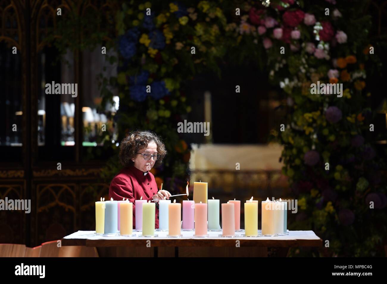 Ein Mitglied des Klerus leuchten Kerzen für die Opfer während der Manchester Arena National Service der Gedenkfeier in der Kathedrale von Manchester zu einem Jahr seit dem Angriff auf Manchester Arena. Stockfoto
