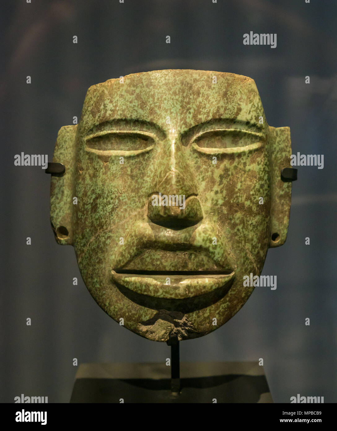 Ausstellung im Museum für präkolumbianische Kunst, Santiago, Chile. Ein grüner Stein gemeißelt Andenkultur Gesichtsmaske Stockfoto