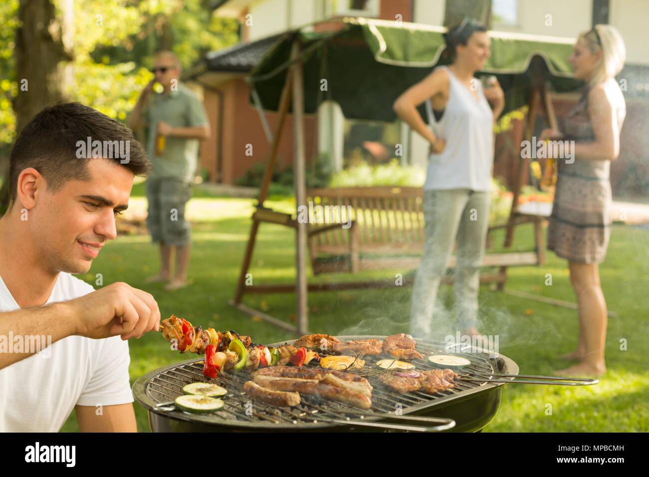 Schuss von einer Gruppe von Freunden grillen im Garten Stockfoto