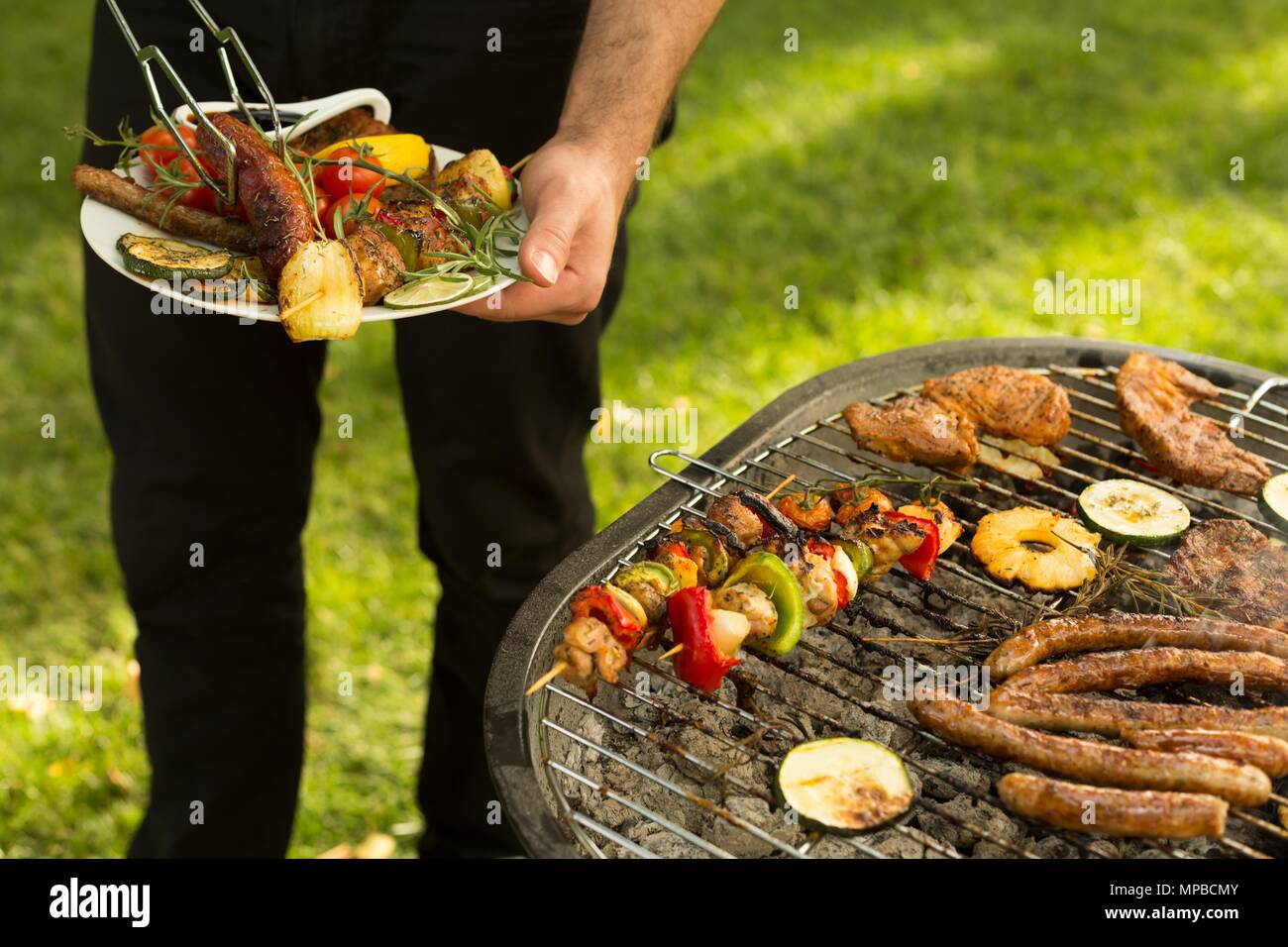 Nahaufnahme der Mann hält Teller voll von gegrillten Speisen Stockfoto