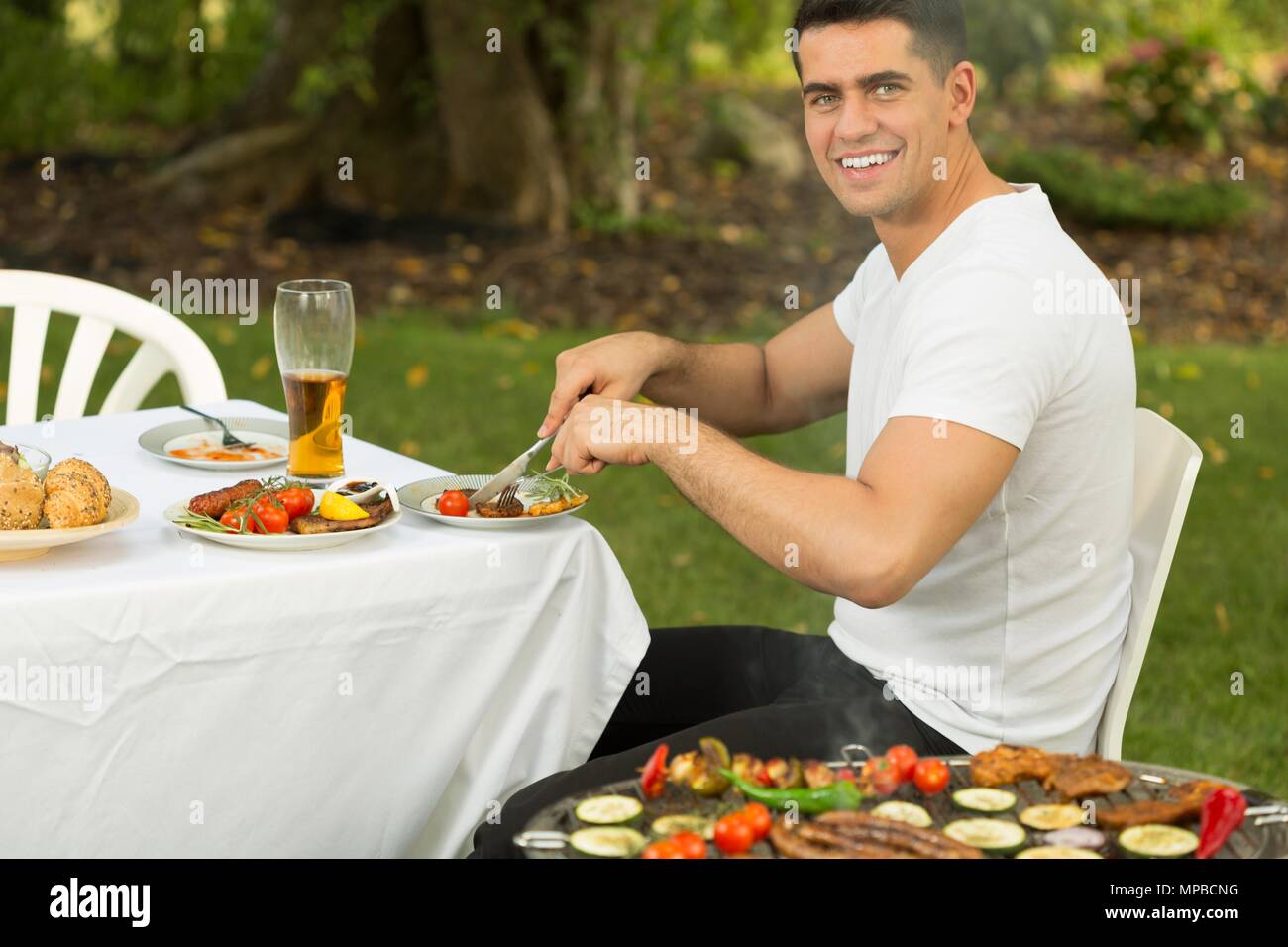 Junge glücklich essen Grill Speisen zum Abendessen Stockfoto